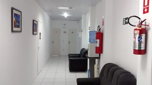 Corredor do prédio do escritório, com sofás de espera e as portas das salas